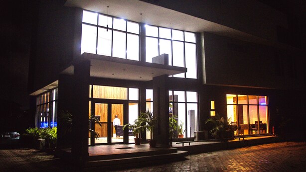 A building with large windows and a paved entrance area. - Hotel Capitol (Lagos)