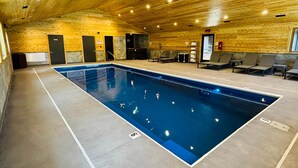 An indoor swimming pool with wooden walls and ceiling, seating areas, and a lifeguard station. - Kenai Fjord/Lakeview 4-6 Person Midsize Cabin (Franklin Township)