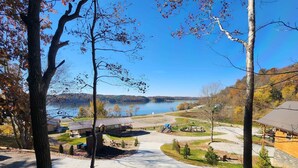 A lakeside view with a picnic area, a small cabin, and a playground. - Kenai Fjord/Lakeview 4-6 Person Midsize Cabin (Franklin Township)