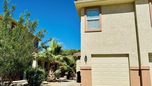 A residential building with a beige exterior, a garage door, and a small window.