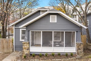 Une maison avec un porche couvert, des fondations en pierre et le numéro « 341 » sur la porte.