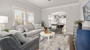 Ein Wohnzimmer mit grauem Sofa, einem Couchtisch und einem blauen Schrank.