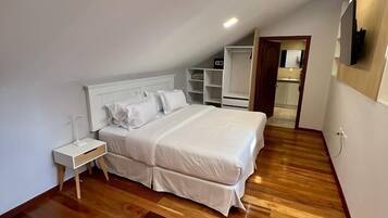 Une chambre à coucher comprenant un lit, des tables de chevet, une armoire et une chaise.