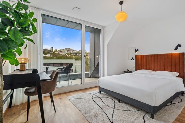 Wake up to stunning city views in this bright, modern bedroom.