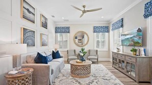 A spacious living room with a sofa, chairs, a coffee table, and a TV. - Steps to Ice Plant, in Downtown St Augustine (St. Augustine)