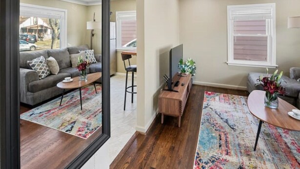 A modern living room with a sofa, coffee table, and TV stand.