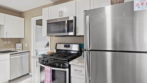 A modern kitchen with stainless steel appliances, including a refrigerator, microwave, and stove.