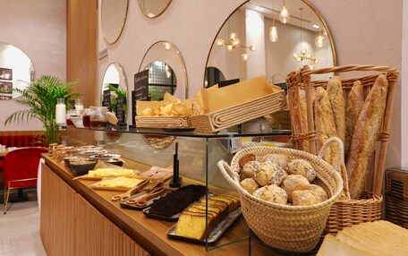 A bakery counter with various baked goods, including bread and pastries, in a cafe setting.