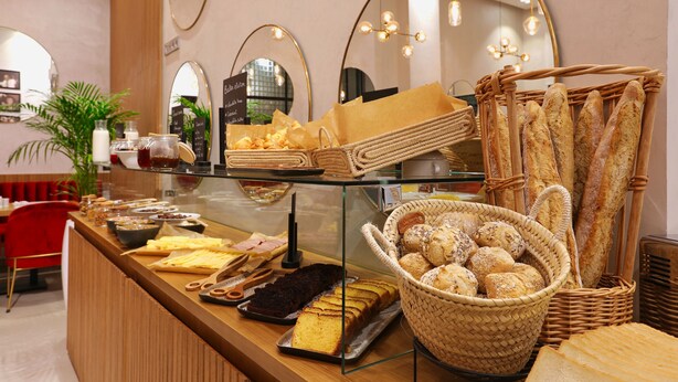 Eine Bäckereitheke mit verschiedenen Backwaren, darunter Brot und Gebäck, in einem Café.