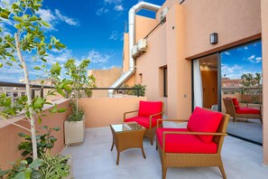 A balcony with wicker furniture, potted plants, and a clear view of the sky. - Ari Boutique Hotel - Adults Only (Marrakech)