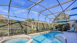 Une piscine extérieure couverte, dotée d’un jacuzzi, de chaises longues et d’une structure en forme de pergola.