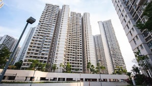 Un edificio residencial alto con varios balcones, techo plano y diseño arquitectónico moderno.
