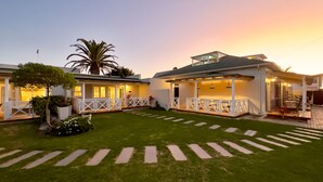 A two-story building with a well-maintained lawn and a paved walkway. - Brigadoon Boutique Guesthouse l Ondili (Swakopmund)