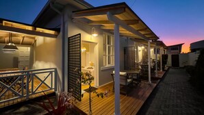 A modern house with a covered patio, a dining area, and a visible kitchen. - Brigadoon Boutique Guesthouse l Ondili (Swakopmund)
