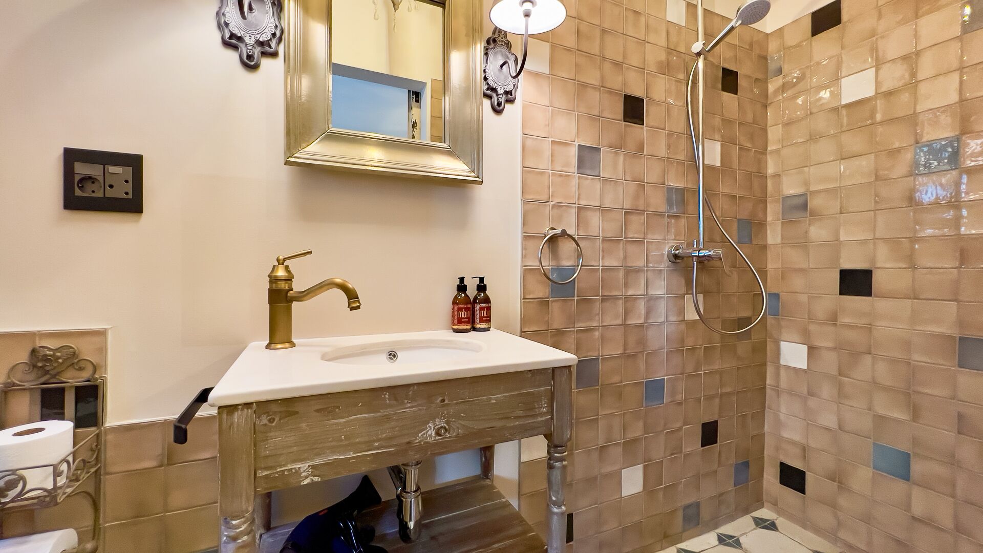A bathroom with a sink, mirror, and shower.