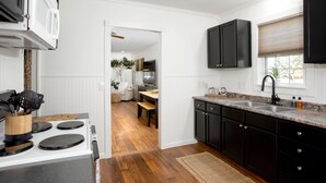 A modern kitchen with a white stove, black cabinets, and a wooden floor. - 2 BR/1BA / IMMACULATE/ DOWNTOWN.
 HIIKE THE CANYON.
PETS WELCOME with SMALL FEE. (Canyon)