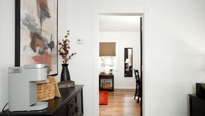 A hallway with a coffee maker, a vase with dried flowers, a framed picture, and a mirror on the wall. - 2 BR/1BA / IMMACULATE/ DOWNTOWN.
 HIIKE THE CANYON.
PETS WELCOME with SMALL FEE. (Canyon)