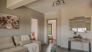 A living room with a sofa, a console table, and a painting. - Queen Bee Residence- Queen Apartment (Minia, Kefalonia)