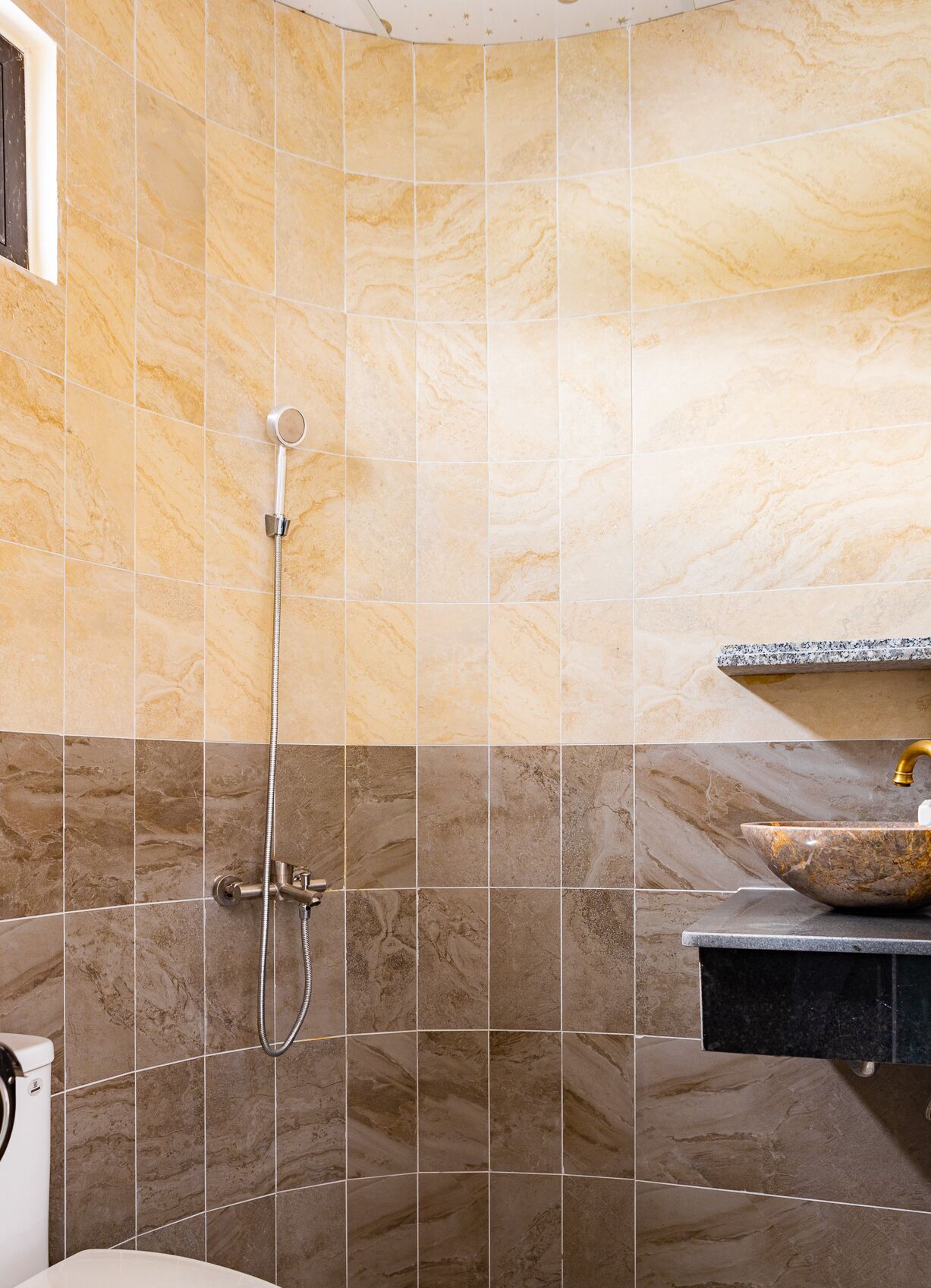 A bathroom with a shower, a sink, and a toilet.