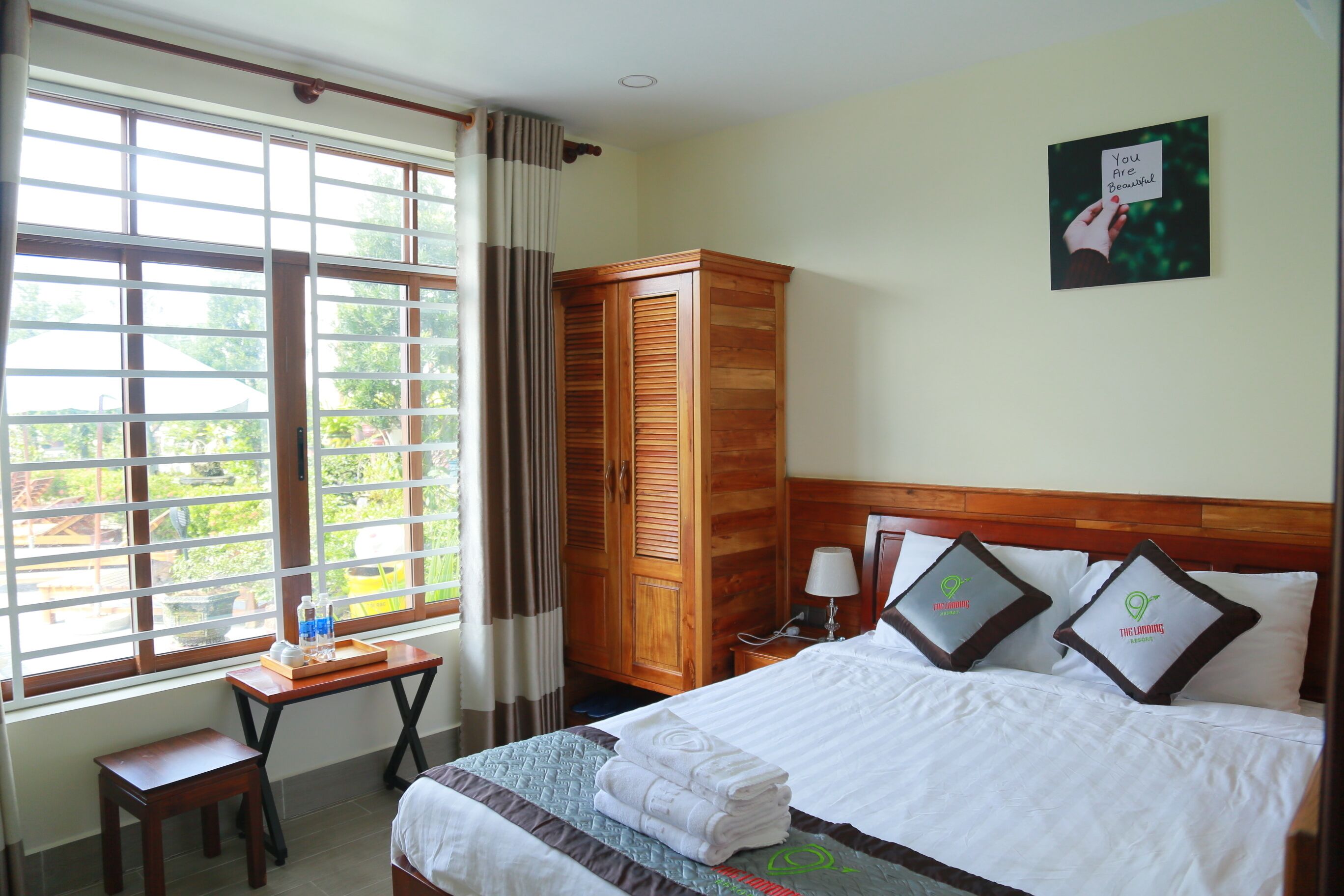 A hotel room with a bed, a desk, and a wardrobe.