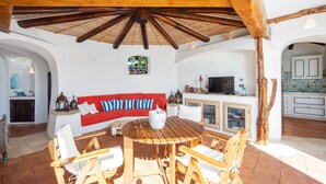 Un espace de vie à aire ouverte comprenant une table et des chaises en bois, un canapé rouge et un téléviseur.
