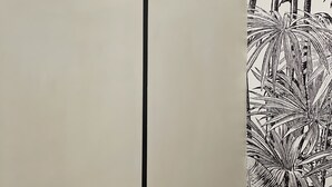 A wall with a black and white striped lamp and a black cross design. - Baboon Room (Rome)