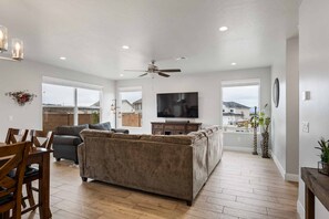 Relax in this spacious living area with a high ceiling, plush sofa, and flat-screen TV.