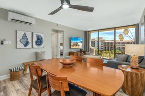 Relax in this spacious living room with a large dining table, comfortable seating, and a TV for entertainment.