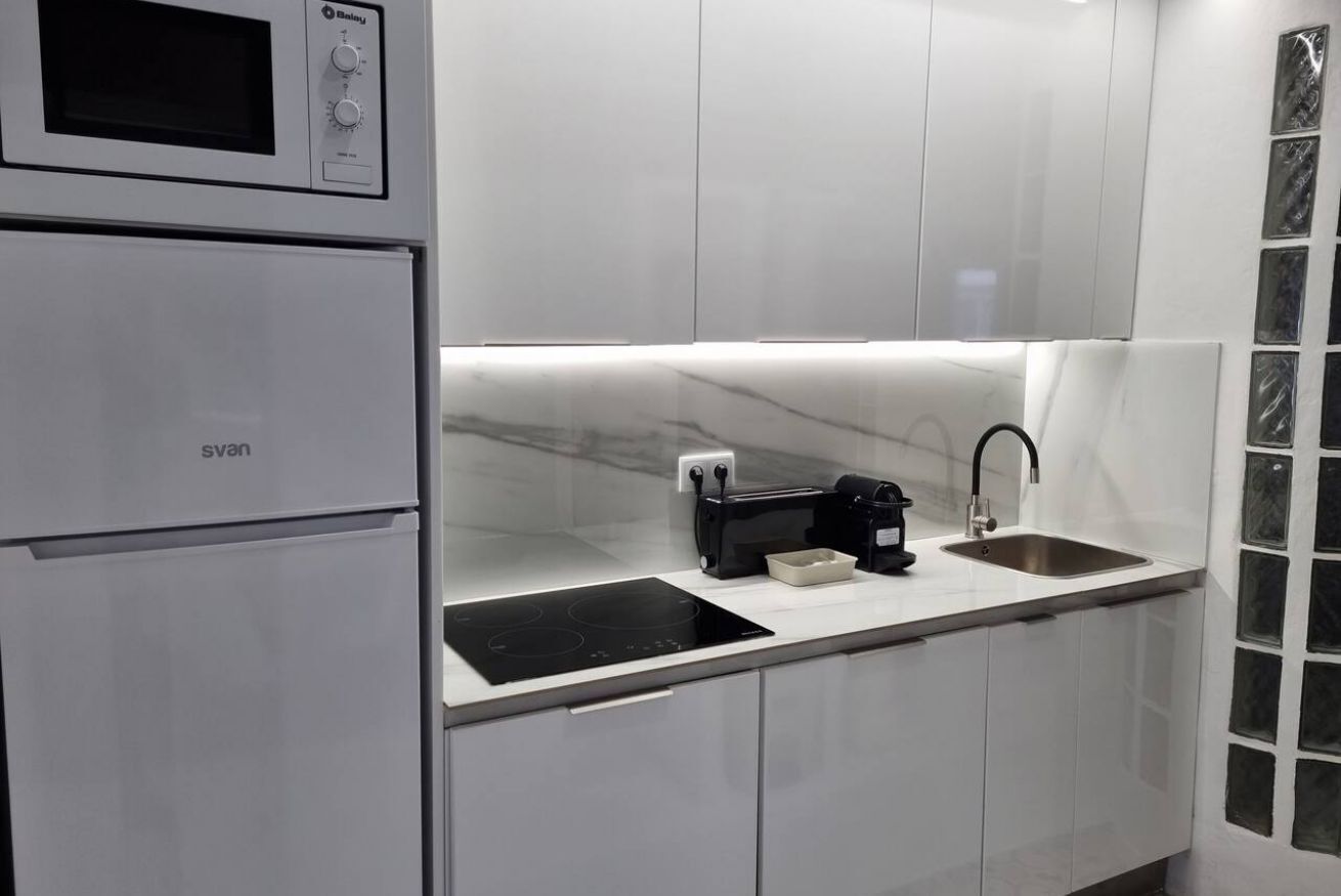 Eine moderne Küche mit Einbau-Mikrowelle, Herd und Spüle.