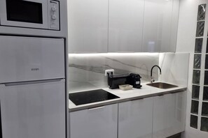 Una cocina moderna con microondas integrado, estufa y pileta.