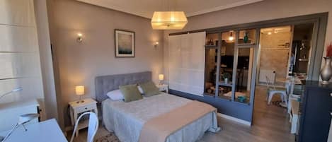 Un dormitorio con cama, mesitas de noche, escritorio y armario.
