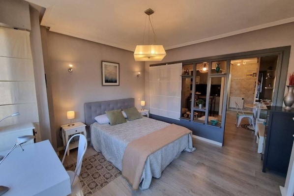 Une chambre à coucher comprenant un lit, des tables de chevet, un bureau et une armoire.