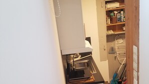 Kompakti keittiö, jossa on sisäänrakennettu astianpesukone, pesuallas ja puulattia.