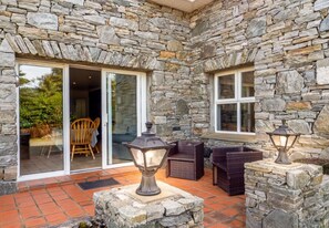 Relax on the patio with wicker furniture and enjoy the view from the sliding glass door leading to a dining area.