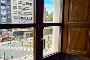 A view through a window with a street scene, including a crosswalk and buildings.