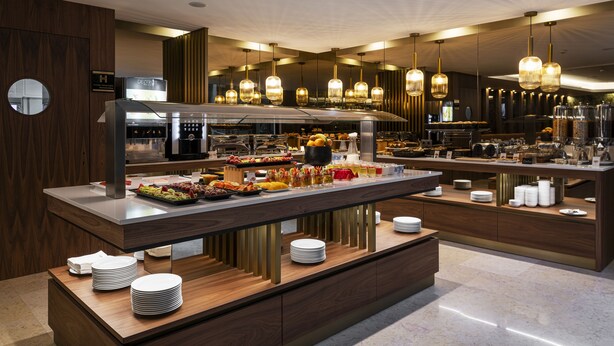 A modern buffet setup with multiple serving stations, a variety of food items, and a clean, contemporary design. - TURIM Oporto Hotel (Porto)