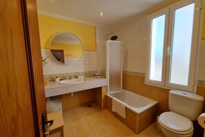 Bañera, secador de pelo, toallas y champú