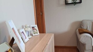 A room with a wooden desk, a beige sofa, and a door.