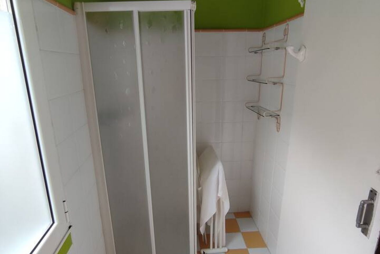 A bathroom with a shower, a towel rack, and a toilet.