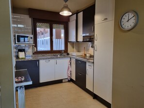 Fridge, microwave, coffee/tea maker, cookware/dishes/utensils