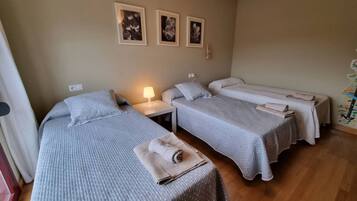 Ein Hotelzimmer mit zwei Betten, einem Nachttisch, einer Lampe und Wandbildern.