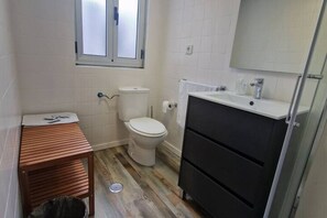 A small bathroom with a toilet, sink, and window.