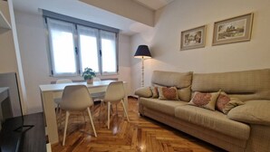 Ein Wohnzimmer mit Sofa, Schreibtisch, Stühlen und einer Lampe.