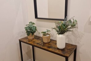 Una consola de madera con tres macetas.