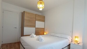 Una habitación de hotel con cama, mesita de noche y armario.