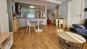 A modern living room with a dining area, a sofa, and a coffee table. - 130A Beautiful Apartment in Cimadevilla by R2R (Gijón)