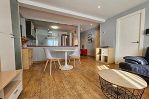 A modern living room with a dining area, a sofa, and a coffee table. - 130A Beautiful Apartment in Cimadevilla by R2R (Gijón)