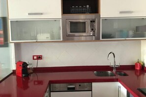 Eine Küche mit Mikrowelle, Kaffeemaschine und Spüle.