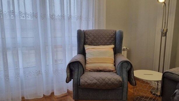 Une pièce comprenant un fauteuil confortable, une table ronde et un lampadaire.