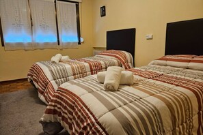 Une chambre d’hôtel avec deux lits, chacun étant équipé de draps à rayures et de serviettes enroulées.